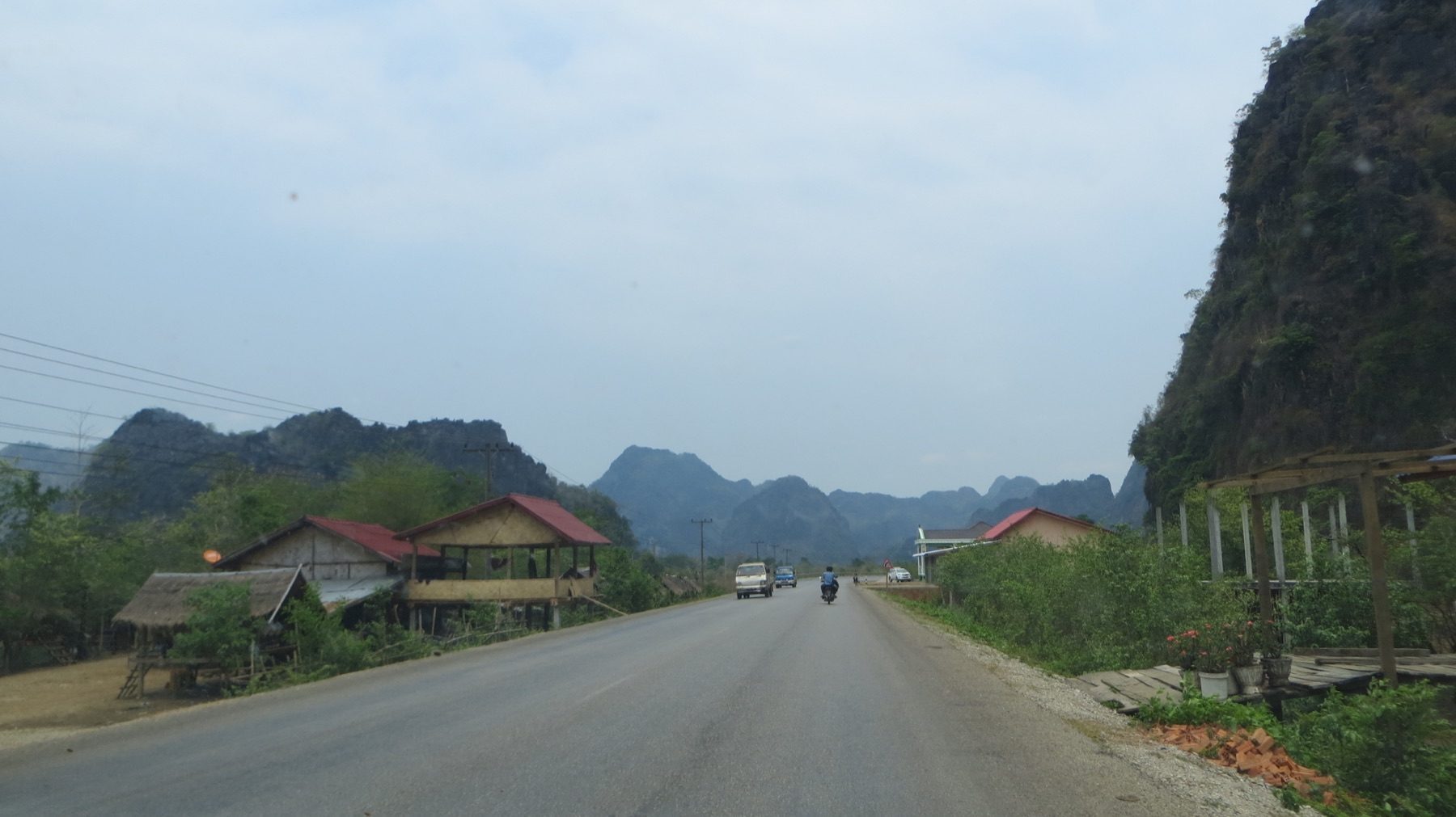 Route traversant un village et les reliefs karstiques du Laos